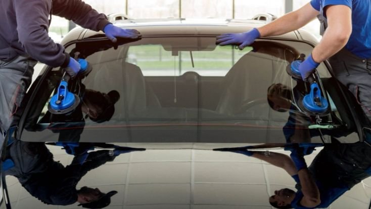 Professional technician fitting a replacement windshield